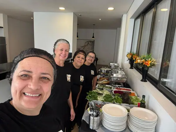 Equipe da Amália em selfie ao lado do buffet montado