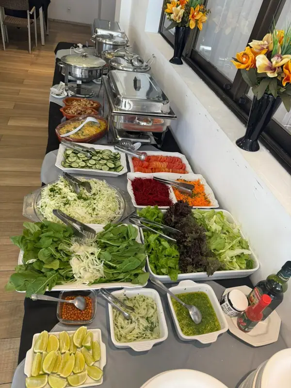 Saladas variadas em mesa de buffet com flores laranja