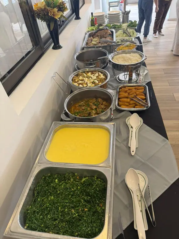 Chafings com polenta e couve refogada em mesa de buffet