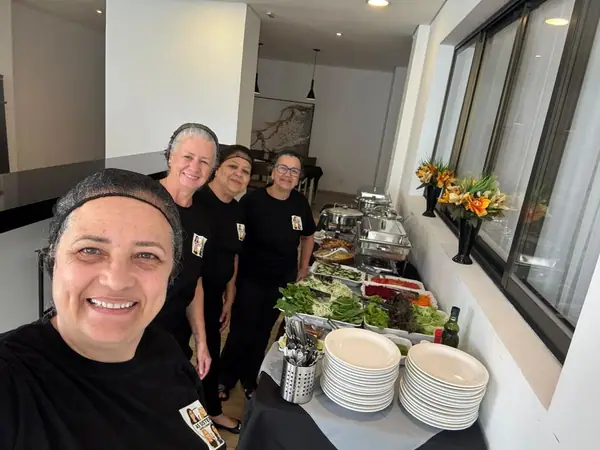 Equipe em selfie diante do buffet