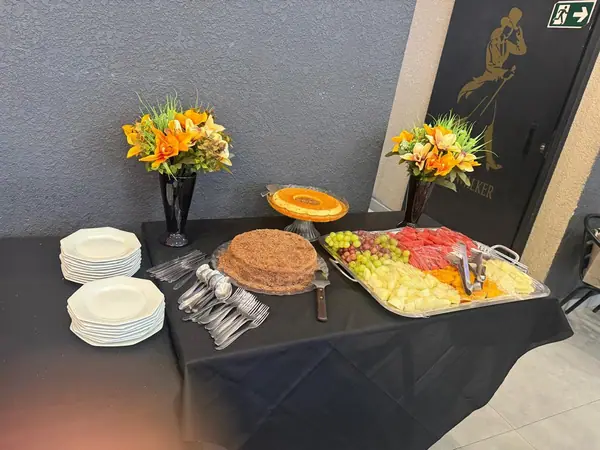 Mesa de sobremesas e tábua de frios com flores laranja