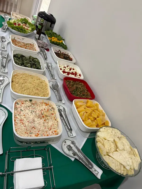 Saladas e acompanhamentos em mesa com toalha verde