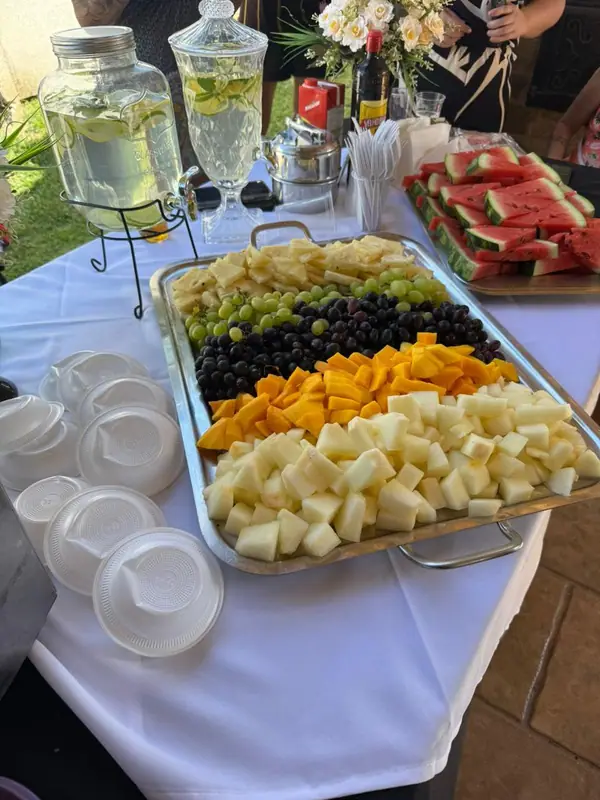 Travessa de frutas e queijos com tigelas ao lado