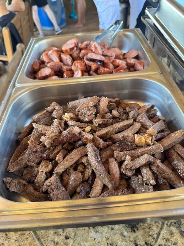Linguiça e carne de churrasco em cubas de inox
