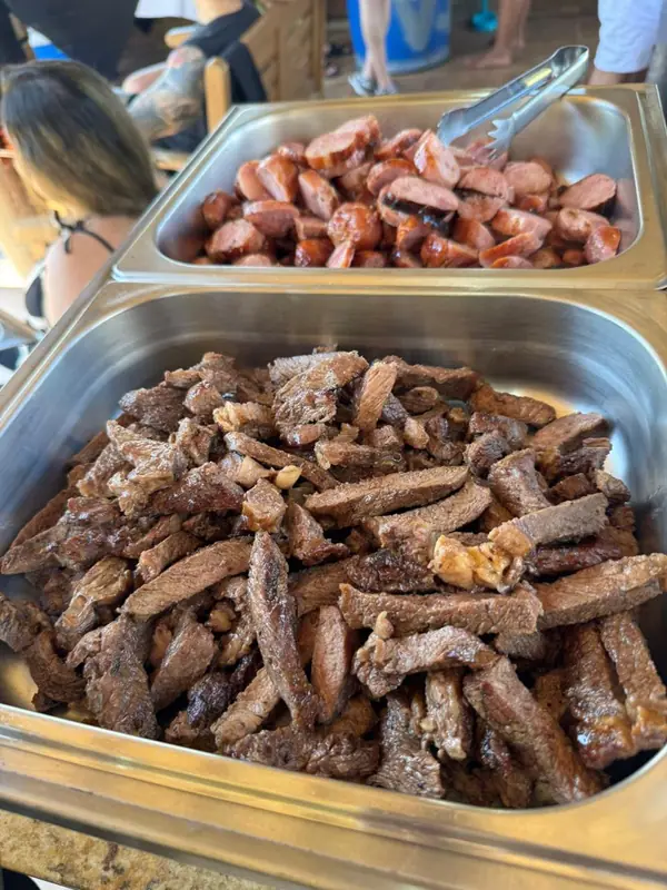 Linguiça e carne de churrasco em cubas de inox