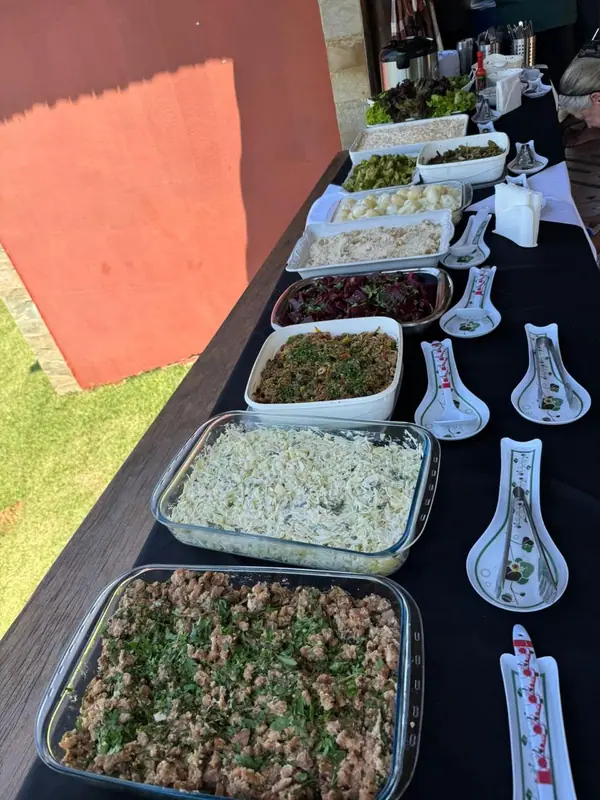 Cubas com saladas e acompanhamentos em mesa preta