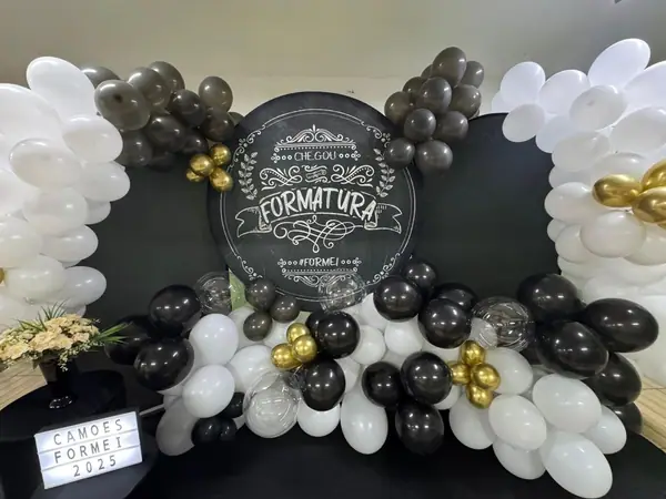 Painel de formatura com balões brancos, pretos e dourados