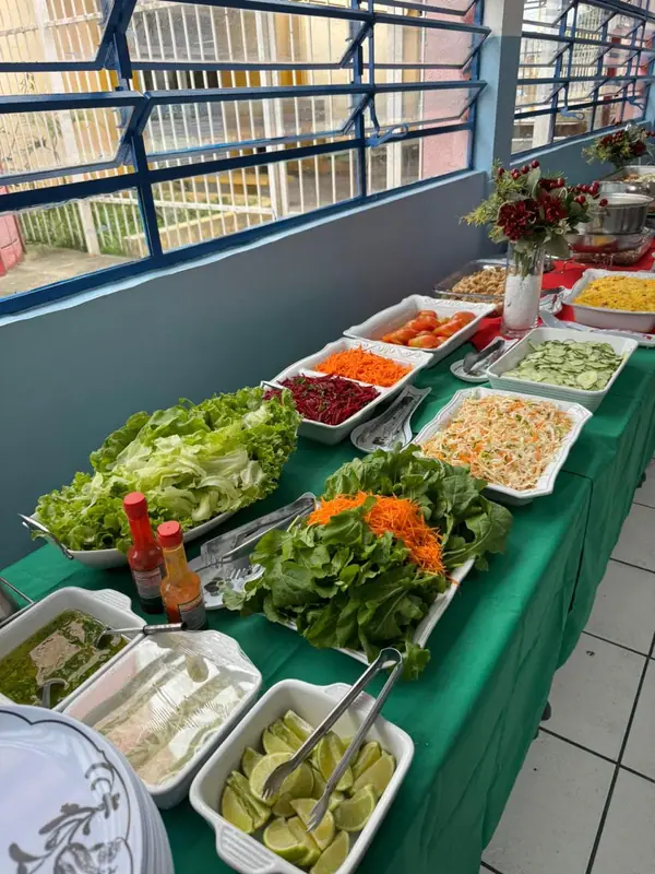 Saladas em mesa de buffet com toalha verde