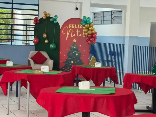 Salão decorado para o Natal com mesas vermelhas