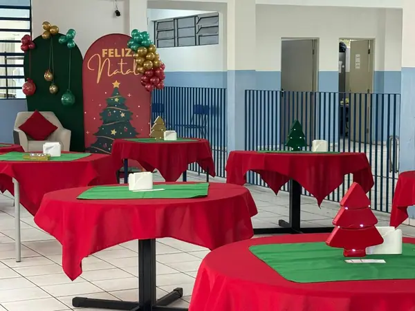 Salão decorado para o Natal com mesas vermelhas