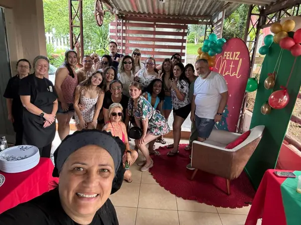 Selfie com convidados diante do painel de Natal
