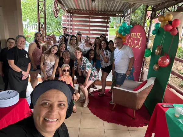 Selfie com convidados diante do painel de Natal