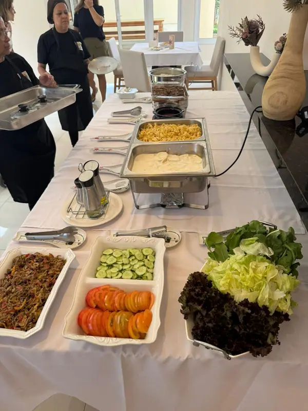 Buffet com chafings, saladas e carnes em mesa branca