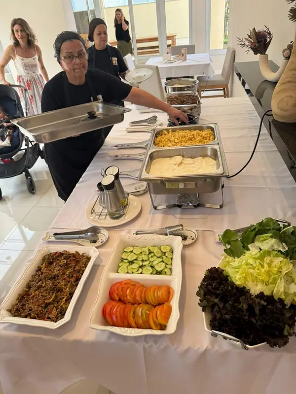 Buffet com chafings, saladas e carnes em mesa branca