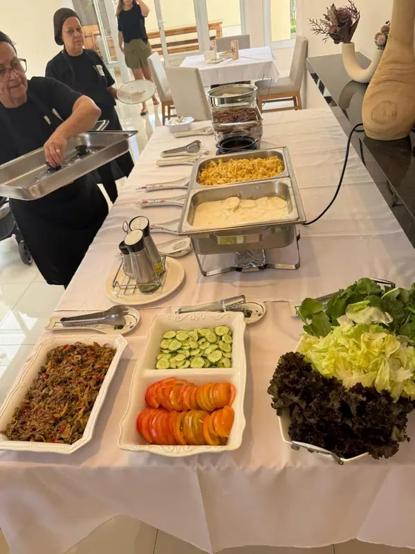Buffet com chafings, saladas e carnes em mesa branca