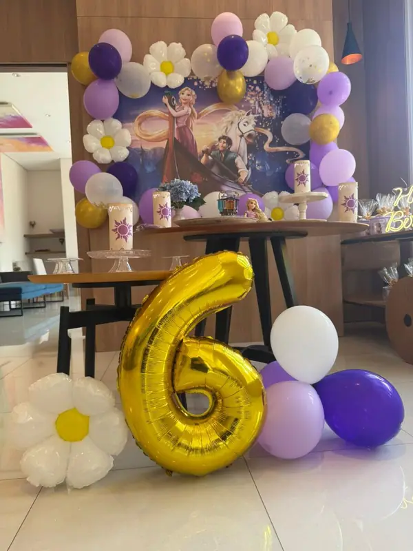 Número 6 dourado e balões roxos na decoração da festa