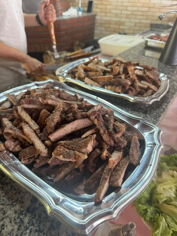 Carnes grelhadas em travessas de inox