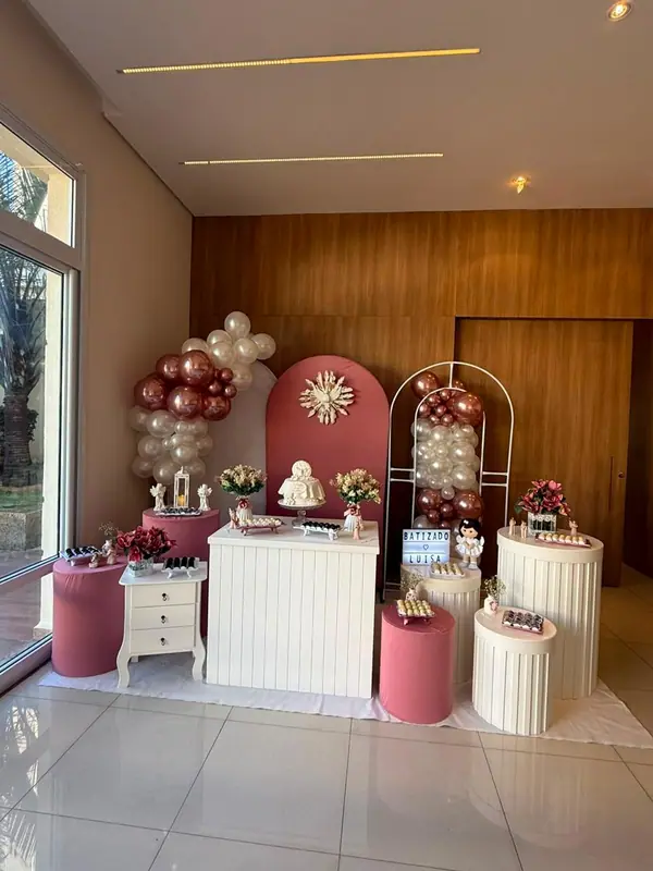 Mesa do bolo e balões rosé em decoração de batizado