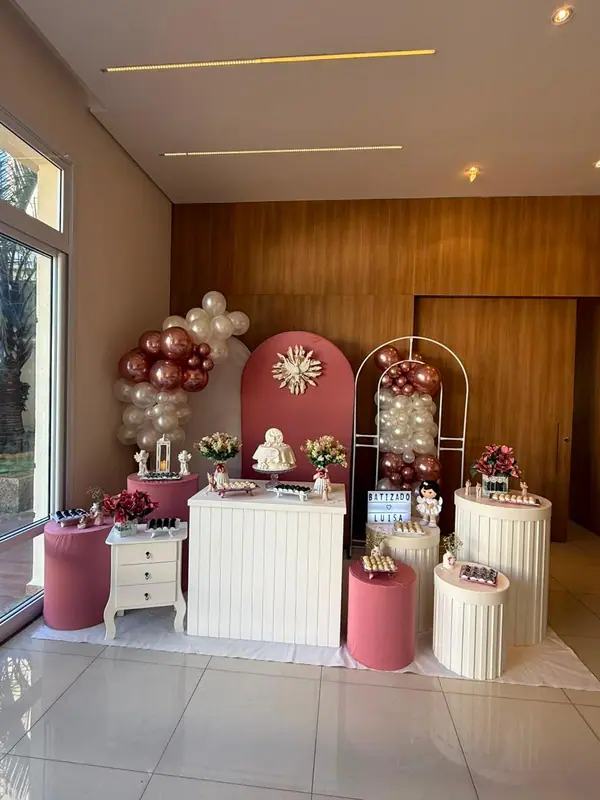 Mesa do bolo e balões rosé em decoração de batizado