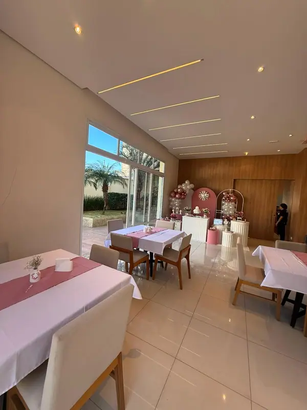 Salão com mesas de toalha rosa