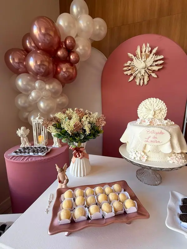 Balões e mesa do bolo em decoração de batizado