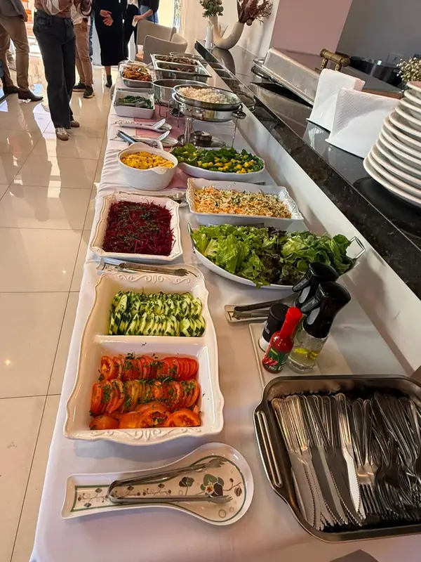 Buffet longo com saladas e pratos quentes