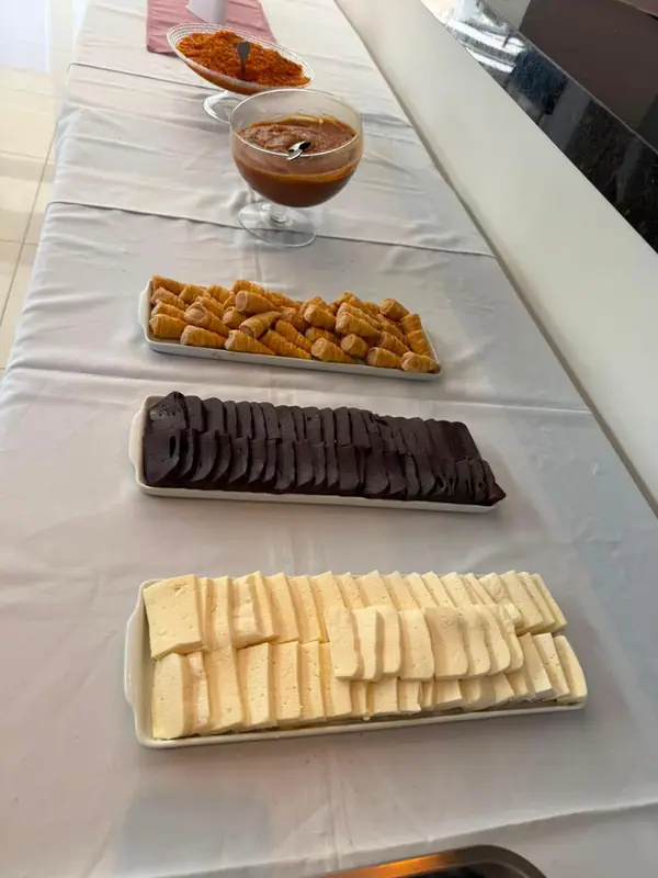 Frios e doces em travessas sobre toalha branca